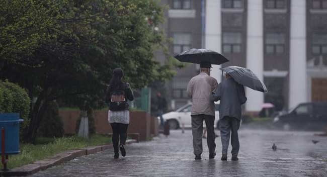 Горожане идут по улице во время дождя. Архивное фото