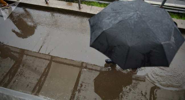Прохожий под зонтом во время дождя. Архивное фото