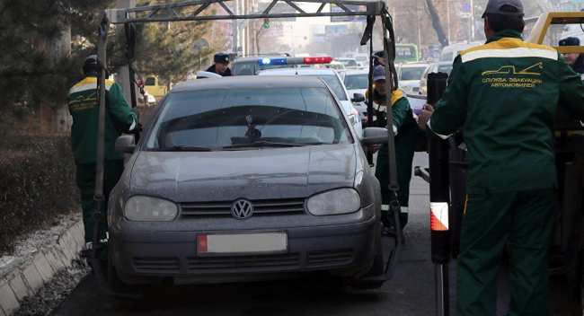 Сотрудники эвакуируют автомобиль за неправильную парковку в Бишкеке. Архивное фото
