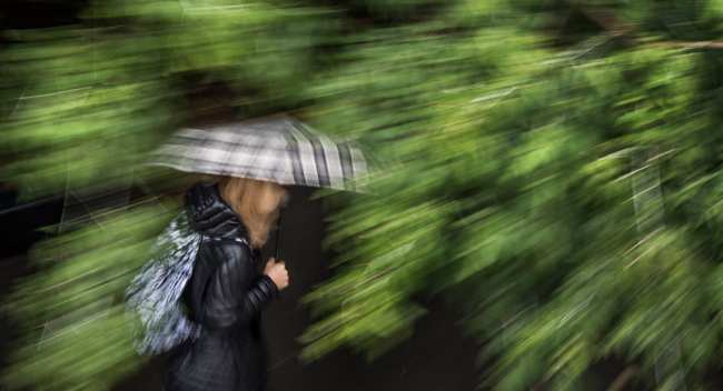 Девушка с зонтом идет по улице во время сильного дождя. Архивное фото
