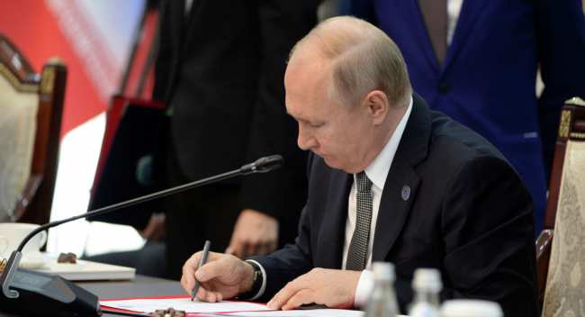 Владимир Путин подписывает документ. Архивное фото