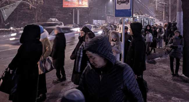 Люди в ожидании общественного транспорта на остановке по улице Киевской в Бишкеке. Архивное фото