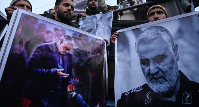 Протестующие в городе Кашмири держат портрет убитого иранского генерала Касема Сулеймани. 3 января 2020 года