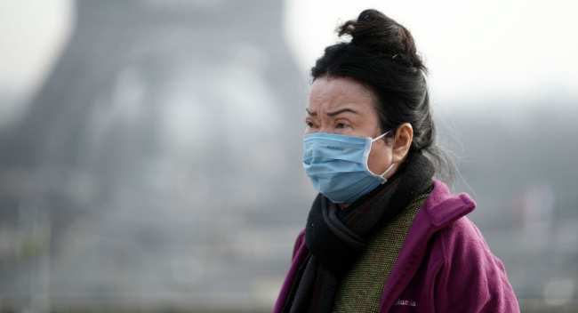 Женщина в медицинской маске в Париже, Франция. 25 января 2020 года