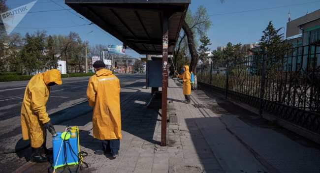 Сотрудники муниципальных служб дезинфицируют остановку общественного транспорта в Бишкеке. Архивное фото